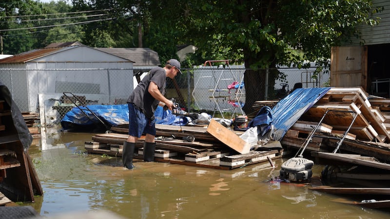Frank Gounder saca equipo de su taller de carpintería afectado por las inundaciones en...