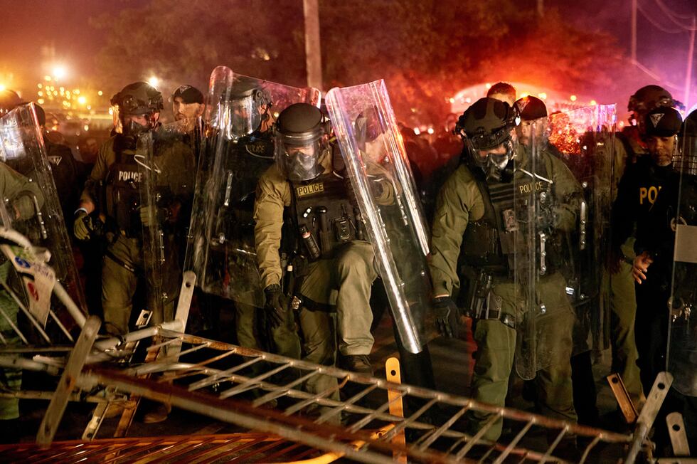 Policías derriban una barricada durante un enfrentamiento con manifestantes cerca del centro...