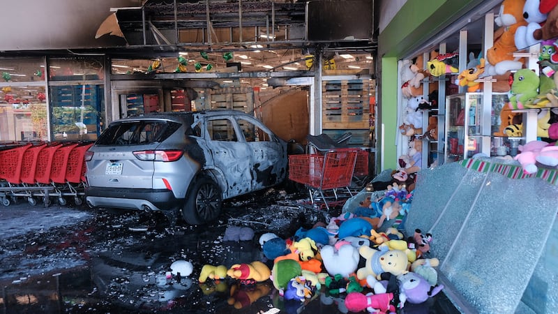 Un vehículo calcinado permanece en un supermercado dañado en Guadalajara, Jalisco, México, el...