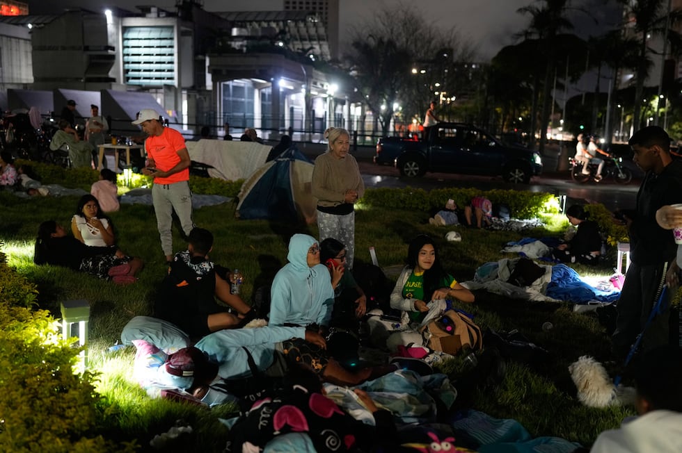 La gente se prepara para pasar la noche al aire libre después de que terremotos sacudieran...