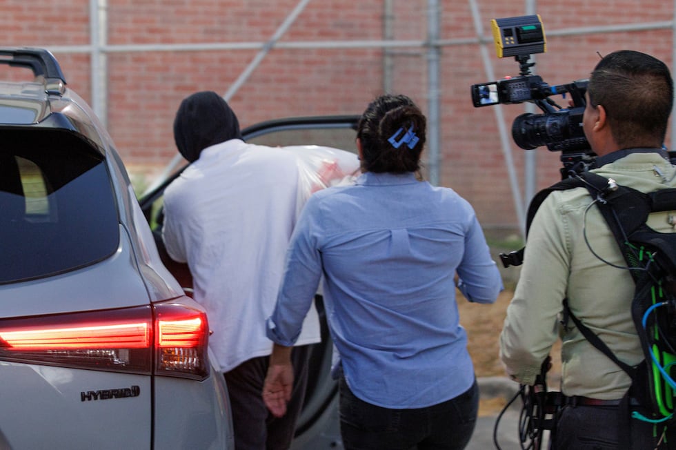 El agente de inmigración Christian Castro sube a un coche rodeado de periodistas momentos...