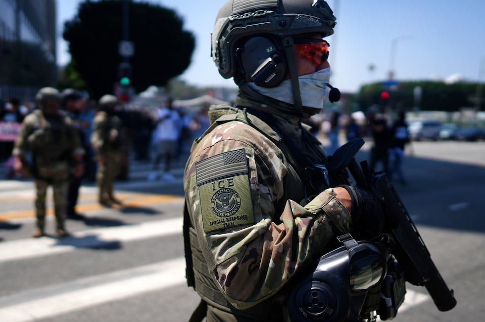 Un agente del ICE observa una manifestación contra las redadas migratorias frente al Centro de...