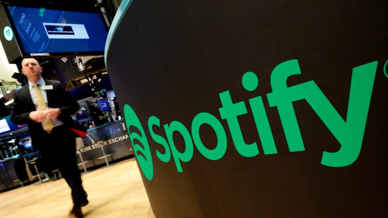 ARCHIVO - Un punto de operaciones bursátiles muestra el logo de Spotify en la Bolsa de Valores...