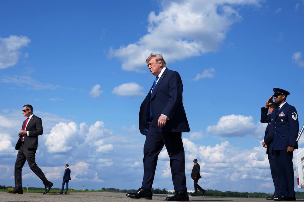 El presidente Donald Trump, en el centro, baja del Air Force One en el Aeropuerto Municipal de...
