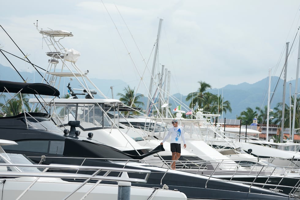 Un hombre cubre una ventana en un barco mientras el huracán Simón se acerca a Puerto Vallarta,...