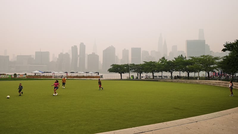 Un grupo de personas juega en el Hunter's Point South Park Athletic Field. Al fondo se...