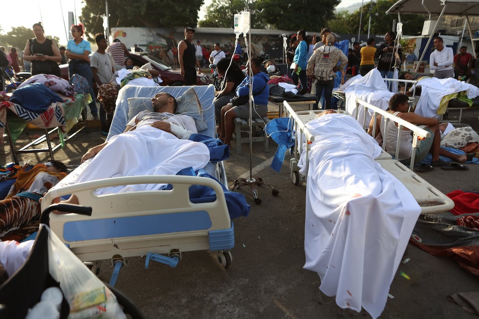 Pacientes yacen en el exterior de un hospital evacuado tras resultar dañado por un terremoto...