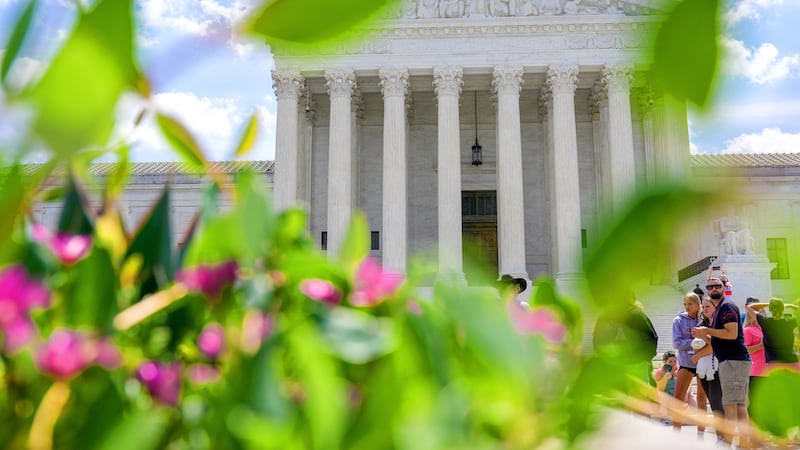 Visitantes caminan frente a la Corte Suprema, el viernes 24 de julio de 2026, en Washington....