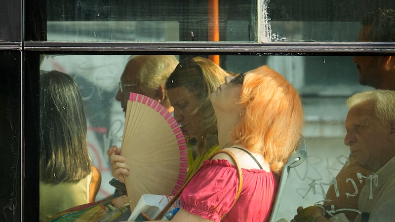 Personas tratan de protegerse del calor en un autobús en Bucarest, Rumania, el 6 de agosto del...